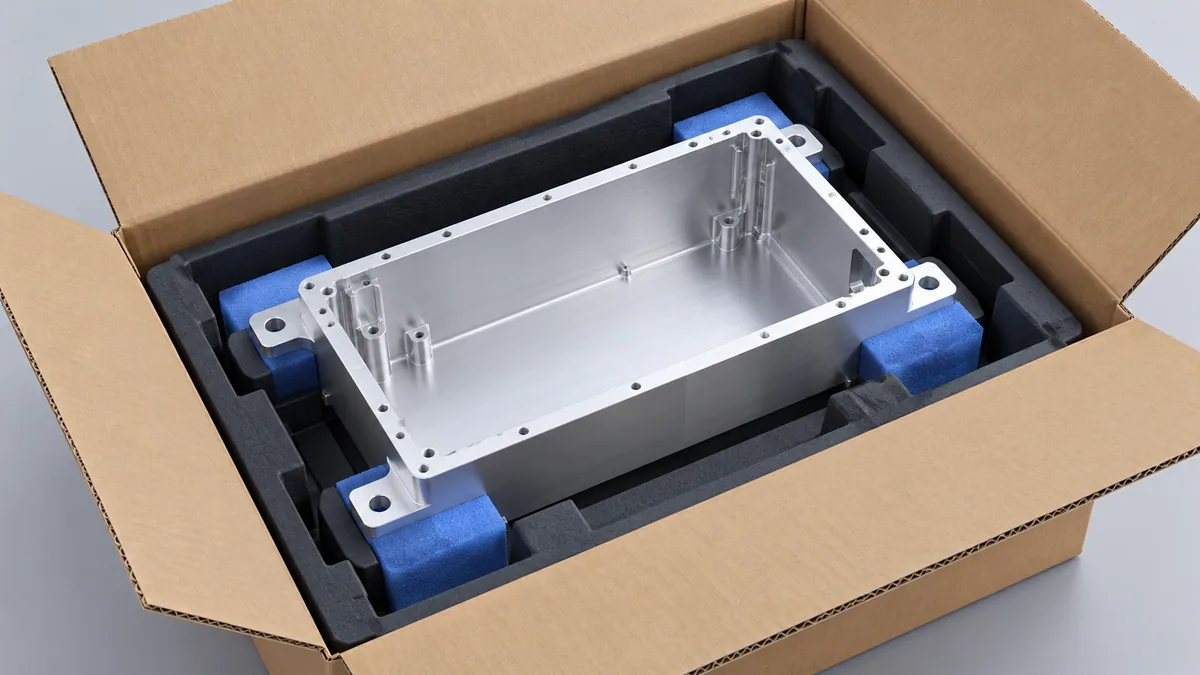 Illustrative thin-wall aluminum housing supported at its broad flange inside a protective shipping tray