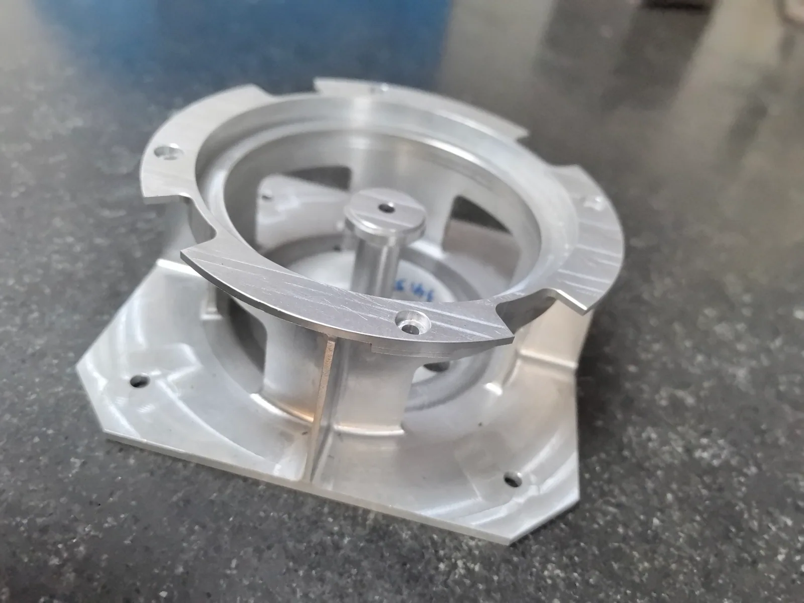 One-piece aluminum component with an upper ring, side windows, connecting webs, central post and shaped mounting base