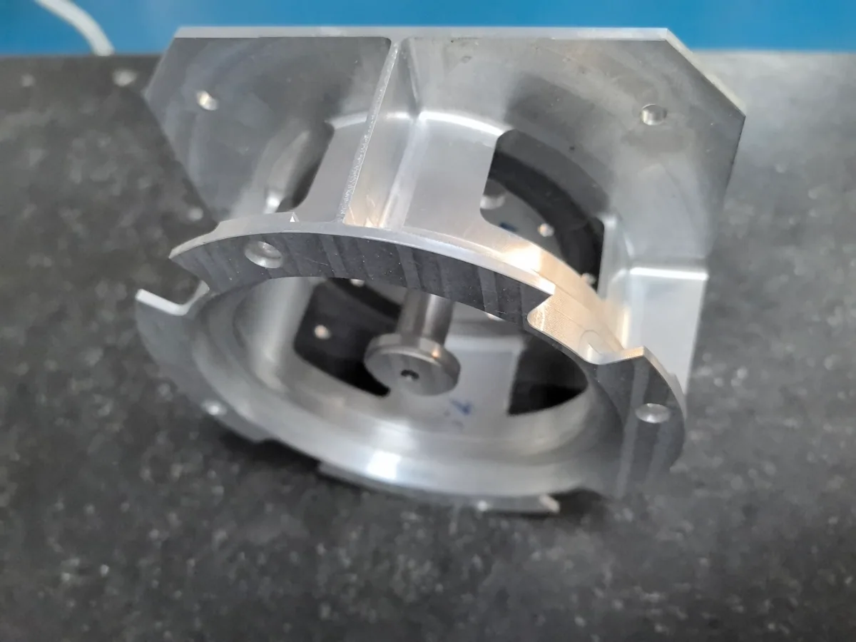 Tilted view into the aluminum component showing the ring, internal post, side openings and mounting base