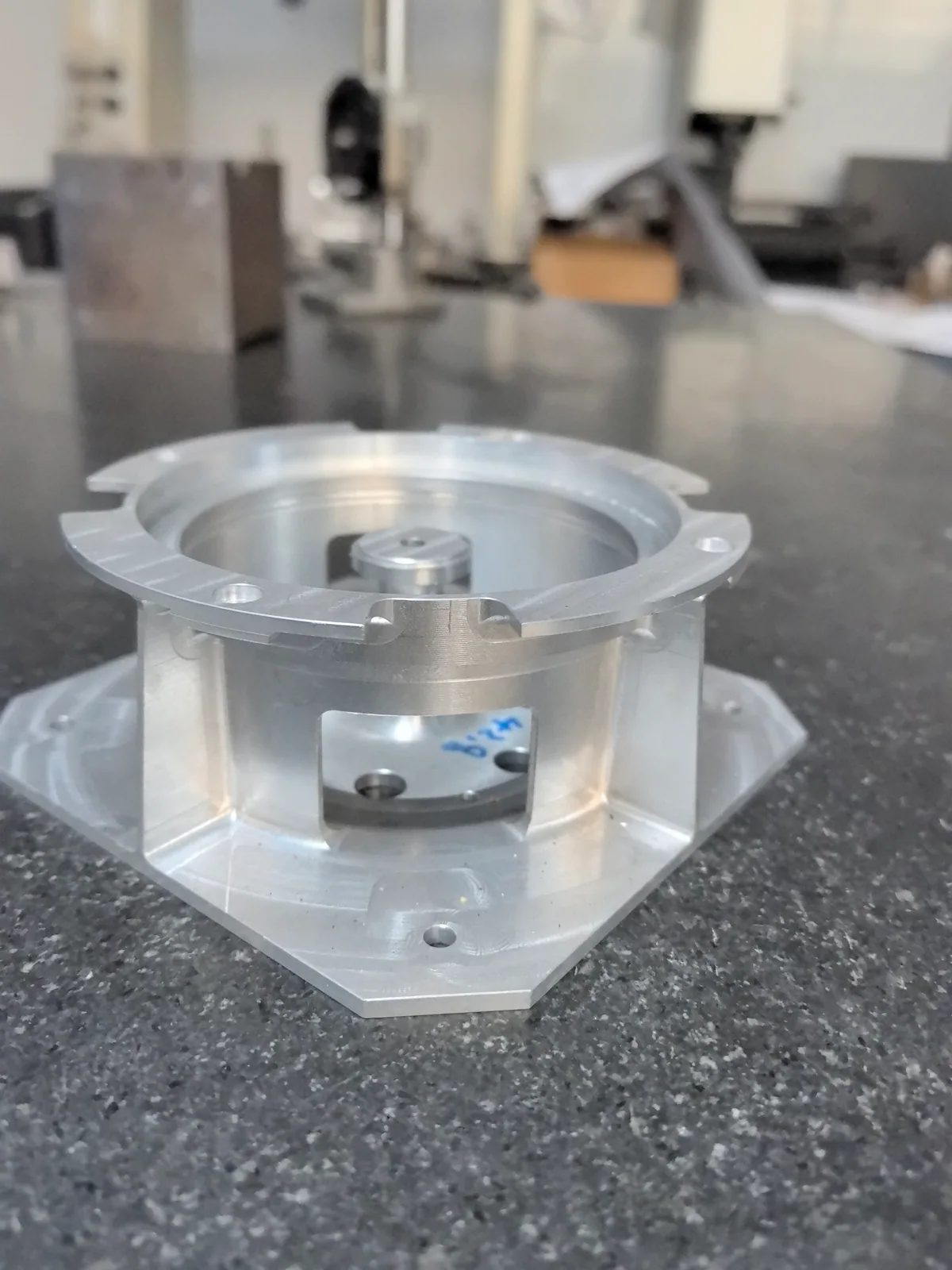 Side window between connecting webs beneath the annular flange of a one-piece aluminum component